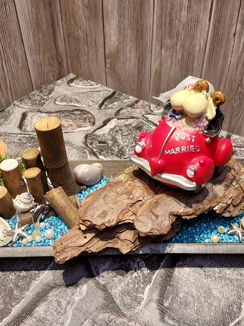 Ein rotes Spielzeugauto mit einem Plüschtierpaar und "Just Married"-Schild.