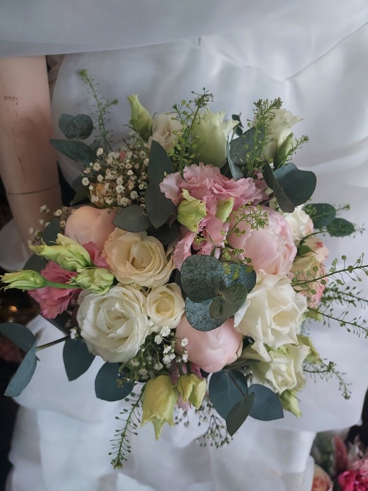 Ein Bouquet aus Rosen und Eukalyptus, überwiegend in Weiß und Rosa gehalten