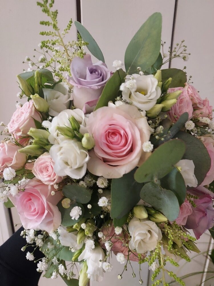 Ein bunter Blumenstrauß mit rosa und weißen Rosen und grünen Blättern