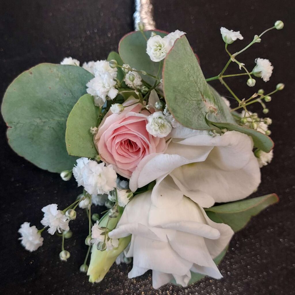 Ein eleganter Blumenstrauß mit rosa und weißen Rosen auf dunklem Hintergrund