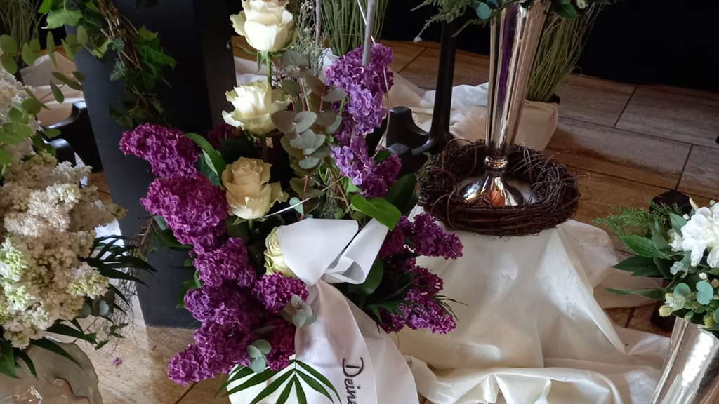 Ein prächtiges Blumenarrangement mit weißen Rosen und lila Blüten.